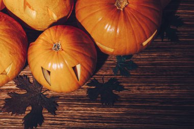 Ahşap arka planda güzel, şık bir Cadılar Bayramı natürmortu. Kuru Akçaağaç Yaprakları ile Jack-o-fener Dekorasyonu. Mutlu Cadılar Bayramı Partisi.