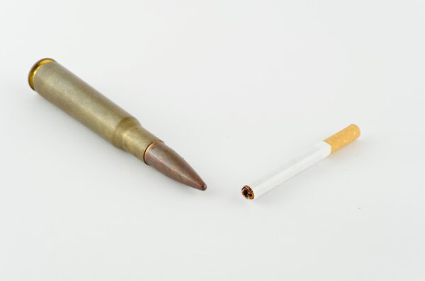 Сигарета и боеприпасы на белом фоне
