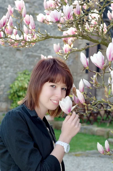 Jovem mulher cheirando flor no jardim — Fotografia de Stock