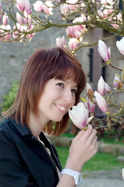 Genç kadın bahçede çiçek kokulu — Stok fotoğraf
