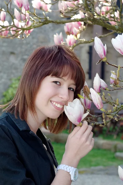 Frau riecht Blume im Garten — Stockfoto
