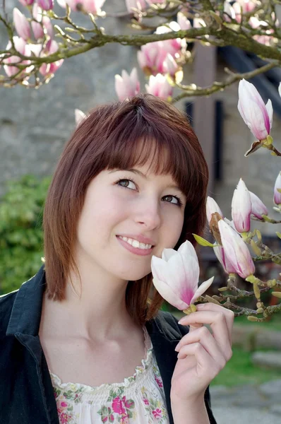 Jonge vrouw ruiken bloem in de tuin — Stockfoto