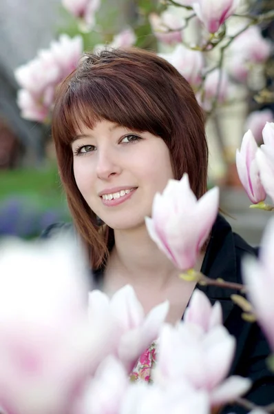 Mujer joven riendo bajo un árbol en el jardín — Foto de Stock