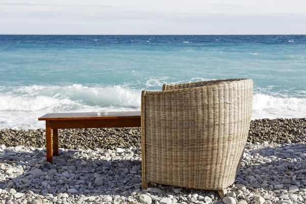 Плетеный стул и деревянный стол — стоковое фото