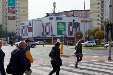 Varşova, Polonya - 6 Ekim 2021: Goclaw bölgesindeki genel görüş insanların caddeyi geçtiği kavşağı ve yaya geçişini gösteriyor. Burada çeşitli binalar da var..