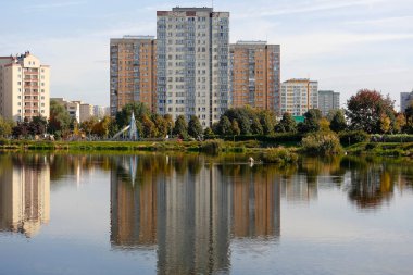 Varşova, Polonya - 11 Ekim 2021: Goclaw 'da birçok ailenin yaşadığı büyük konut binaları, yansımalarının görülebildiği göl kıyısında yer alır.