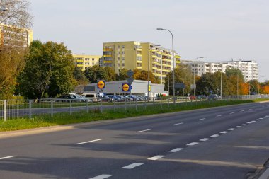 Varşova, Polonya - 6 Ekim 2021: Goclaw 'da geniş caddenin karşısında birçok apartman var. Tanınmış bir markanın indirim zincirine ait bir otopark ve mağazayı fark edebilirsiniz..