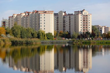 Varşova, Polonya - 11 Ekim 2021: Pek çok ailenin yaşadığı Goclaw yerleşim bölgesi, göl kenarındaki ağaçlar ve bitkiler arasında yer almaktadır ve güneşli bir günde burada görülebilmektedir.