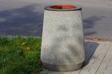 Polonya 'nın Varşova kentindeki Goclaw konut bölgesinde, caddenin yakınındaki kaldırımda çimlerin yanına beton bir çöp konteynırı yerleştirildi..