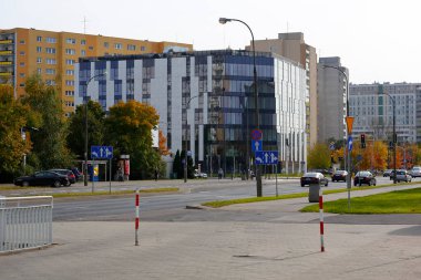 Varşova, Polonya - 20 Ekim 2021: Modern bina Goclaw denilen malikanenin geniş caddelerinin diğer tarafında yer almaktadır. Sokakta hiç trafik yok..