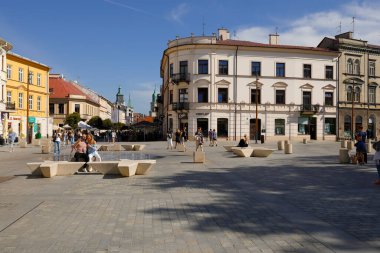 Lublin, Polonya - 10 Eylül 2021: eski şehir konutlarıyla çevrili büyük bir meydan. Meydanda küçük bir çeşme var ve insanlar orayı ziyaret ediyor.