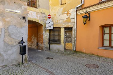 Lublin, Polonya - 11 Eylül 2021: Asfalt sokaktaki eski apartman evleri şehrin eski kesiminde yer almaktadır. Bu binaların yakınında ne insan ne de araç var.