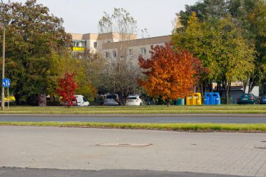 Varşova, Polonya - 20 Ekim 2021: Şehir sokağının arkasında bir iskan binası, yakınlarda ağaçlar ve Goclaw konut bölgesinde görülebilen park edilmiş arabalar var.