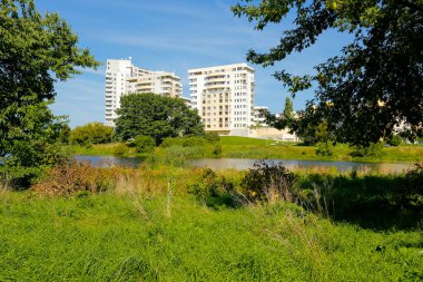 Varşova, Polonya - 3 Eylül 2021: Praga Poludnie bölgesindeki Goclaw bölgesinde Przyczolek Grochowski malikanesinde çok katlı binalar var. Gölün etrafında büyük bir çim var.