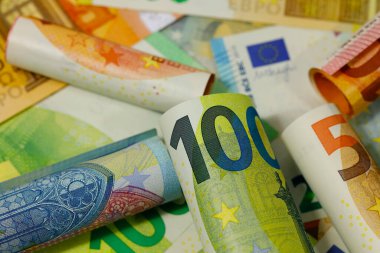 Yan yana yerleştirilmiş Avrupa Birliği banknotları vardır. Euro banknotları kağıttan değil, dayanıklılıklarını artırmak için saf pamuk lifinden yapılmıştır. EUR para birimi.