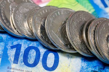 CHF para birimi. İsviçre frangı banknotların arka planında yan yana istiflenmiş madeni paralar artık çeşitli mali meseleler için bir zemin..