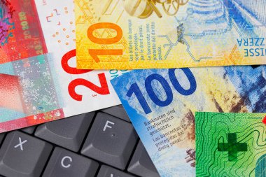 İsviçre frangı banknotları çeşitli banknotlar, bir bilgisayar klavyesinde yan yana dizilmiş. CHF kağıt para, İsviçre banknotlarının basımı, Nisan 2016 'dan 2019' a kadar yayınlandı.