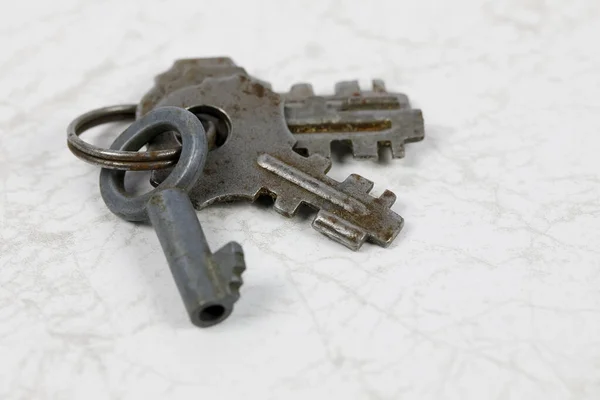 旧挂锁用的旧钥匙放在大理石底座上 — 图库照片