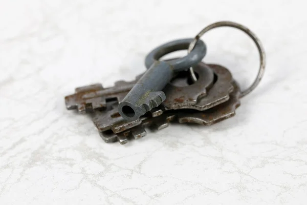 旧挂锁用的旧钥匙放在大理石底座上 — 图库照片