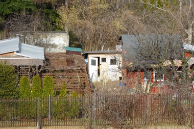 Varşova, Polonya - 23 Ocak 2022: Praga Poludnie bölgesindeki Goclaw konutlarının bahçelerindeki bitkilerle çevrili küçük yazlık evler.