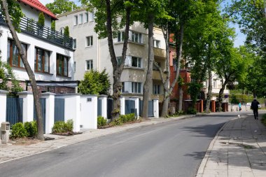 Gdynia, Poland - May 30, 2022: Residential buildings in a quiet neighborhood built along a narrow city street with no traffic now.