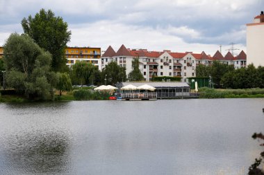 Warsaw, Poland - July 7, 2022: Overall view of the residential buildings by the park and lake in the Goclaw estate, in the Praga Poludnie district.