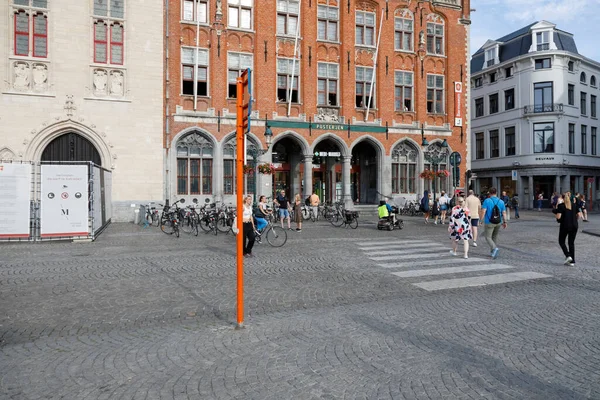 比利时布鲁日 2022年9月7日 一座大砖楼 毗邻鹅卵石城广场 有人在人行横道上过马路 有人在人行道上走着 — 图库照片