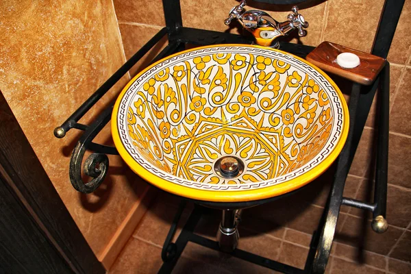 Washbasin with old prints in yellow — Stock Photo, Image