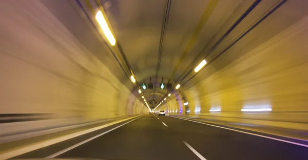 Moderna lång motorväg tunnel i ett gult ljus — Stockfoto