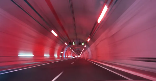 Moderno túnel de carretera largo en una luz roja —  Fotos de Stock