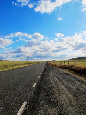 Mavi gökyüzü ve beyaz bulutlarla dolu güzel bir köy yolu.