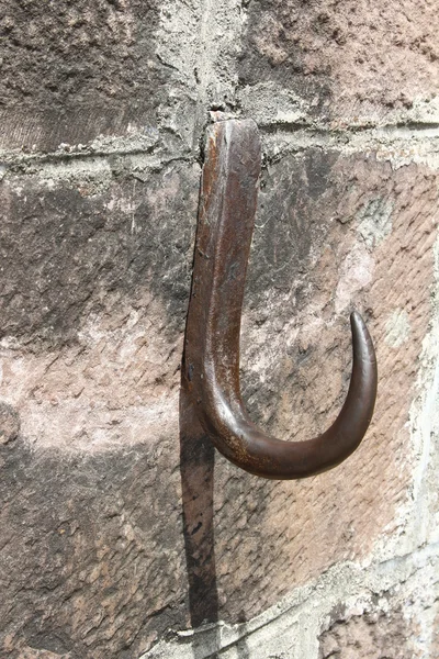 Old iron hook on a wall of granite — 图库照片