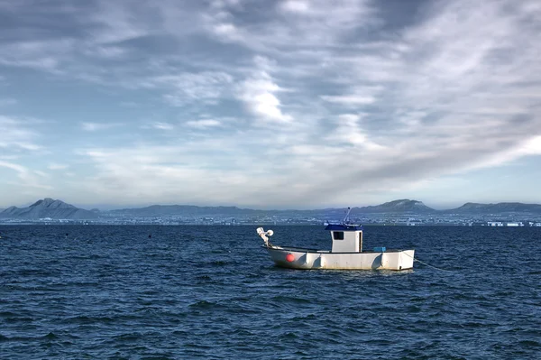 Fiskare som fiskar i havet i en liten båt — Stockfoto