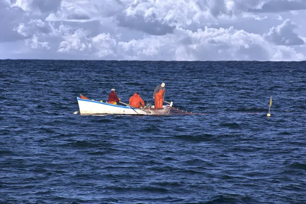 在一条小船在海上捕鱼的渔民 — 图库照片