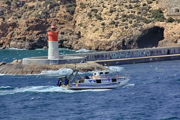 Μικρό αλιευτικό σκάφος που πλέει κοντά στην ακτή σε μια μπλε θάλασσα — Φωτογραφία Αρχείου