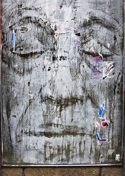 Dessiner un visage sur un morceau de verre dans un bâtiment abandonné — Photo