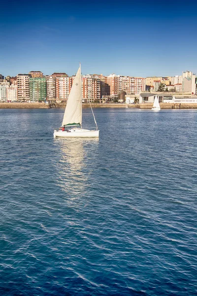 Small sailboat white sailing in front of the city of Santander, — Stock Photo, Image