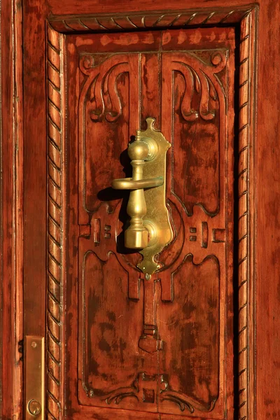 Деревянная дверь с медной ручкой — стоковое фото