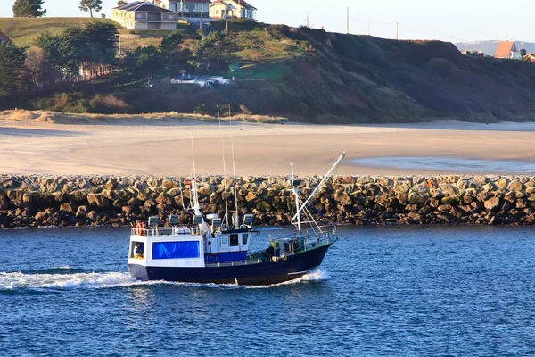 Pequeño barco de pesca que navega cerca de la costa en un mar azul — Foto de Stock
