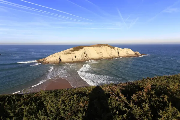 Île reliée par une flèche de sable à la côte, avec des vagues sur deux — Photo