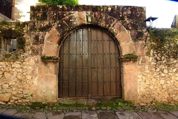 Oude houten deur in de stad van santillana del mar, Spanje — Stockfoto