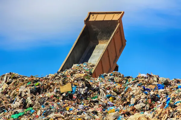 Lossning lastbil i ett berg av skräp — Stockfoto