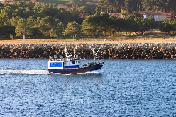 Pequeño barco de pesca que navega cerca de la costa en un mar azul — Foto de Stock