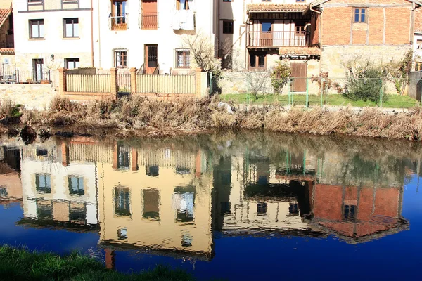 Landskap av floden och byn i aguilar de campo, känd för sina kex i Spanien — Stockfoto