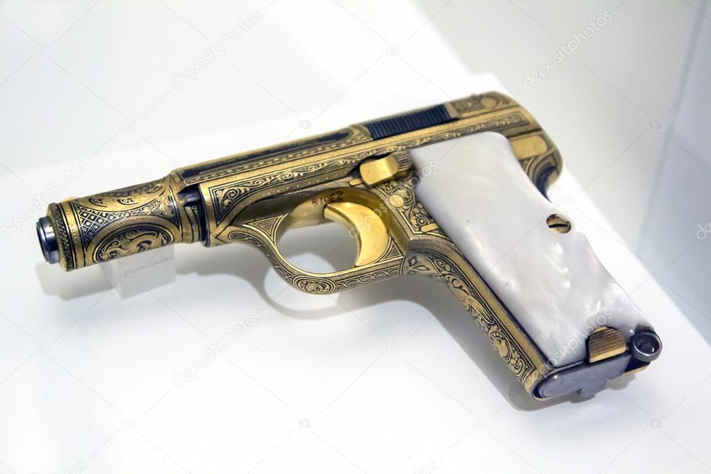 beautiful antique pistol, decorated in gold with white pearl gri