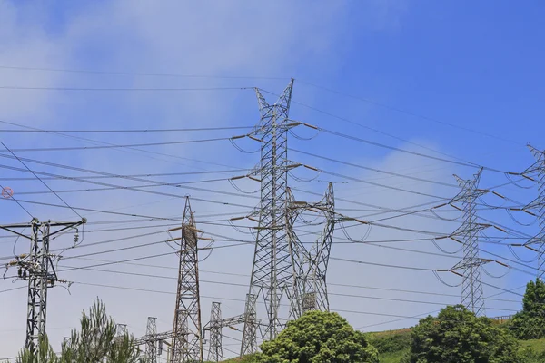 Hoogspanning elektrische torens in een groen veld — Stockfoto