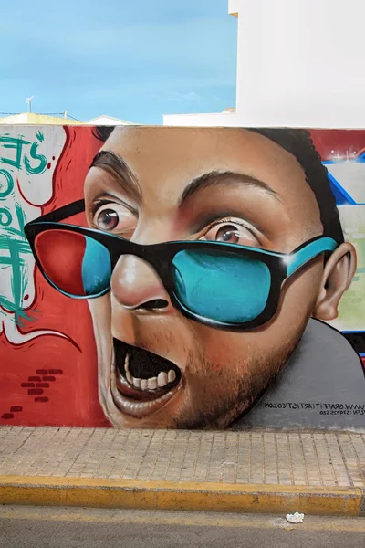 Mur peint avec un visage avec des lunettes sur la rue de la ville — Photo