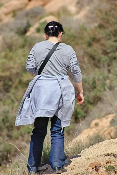 Back woman walking in the countryside — Stock Photo, Image