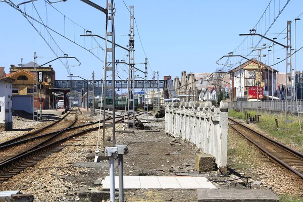 Železniční vlak do stanice, s mnoha utility póly — Stock fotografie