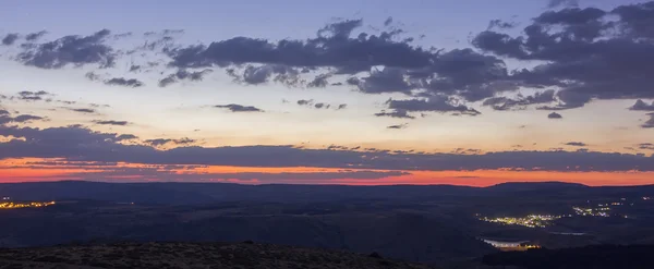 Puesta de sol en las montañas con luces de la ciudad —  Fotos de Stock